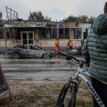 A boy with a bicycle looks on near buildings damaged during a Russian drone and missile strike amid Russia's attack on Ukraine, in the town of Brovary, outside of Kyiv, October 10, 2025. REUTERS/Alina Smutko     TPX IMAGES OF THE DAY