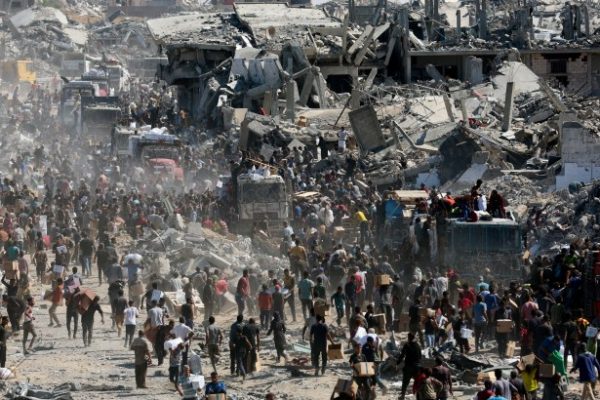 Palestinians collect aid supplies from trucks that entered Gaza, amid a ceasefire between Israel and Hamas, in Khan Younis, in the southern Gaza Strip October 12, 2025.