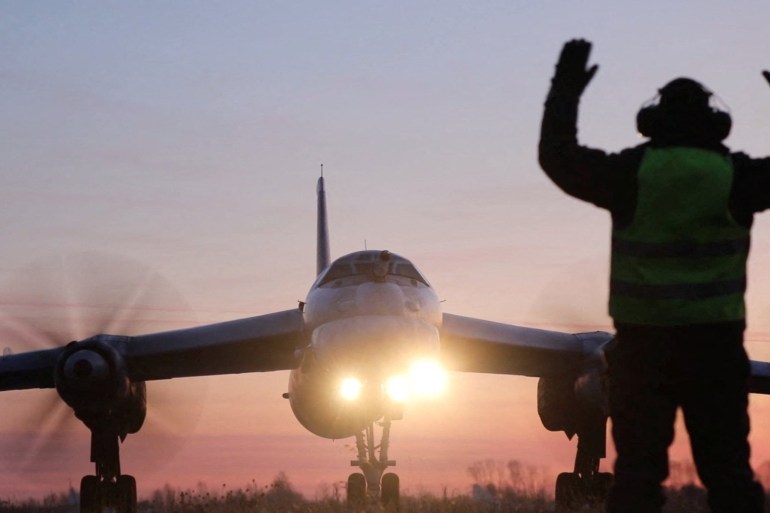 A ground crew marshaller guides a Russian Tu-95MS nuclear-capable strategic bomber performing a flight over neutral waters in the Sea of Japan, in this still image taken from a video released on October 24, 2025. Russian Defence Ministry/Handout via REUTERS ATTENTION EDITORS - THIS IMAGE HAS BEEN SUPPLIED BY A THIRD PARTY. NO RESALES. NO ARCHIVES. MANDATORY CREDIT