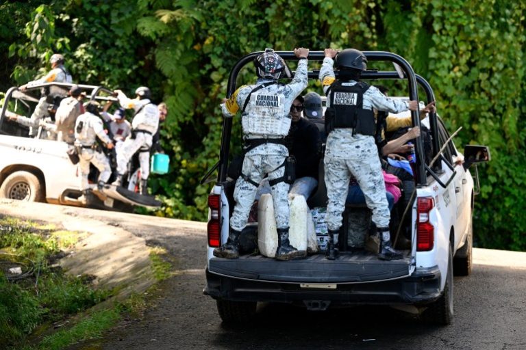 Members of the National Guard transport residents along the Tulancingo–Tenango road to Tulancingo after heavy rains in Hidalgo state, Mexico, on October 12, 2025. The death toll from heavy rains in Mexico rose to 44 after the Mexican government confirmed three more fatalities on Sunday, as civilian and military rescuers struggle to clear roads and reach cut-off communities. (Photo by Alfredo ESTRELLA / AFP)
