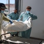 Hospital workers transport the remains of a Palestinian released by Israel under a Gaza ceasefire and hostage exchange deal, to the morgue of Nasser hospital in Khan Yunis in the southern Gaza Strip, on October 18, 2025. Israel returned the bodies of 15 Palestinians to Gaza on October 18, bringing the total number handed over to 135, the health ministry in the Hamas-run territory said.