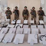 In this image provided by the Myanmar military on Oct. 19, 2025, soldiers stand next to Starlink machines as they seize KK Park online scam center in Myawaddy township, Karen State, Myanmar. (The Myanmar Military True News Information Team via AP)
