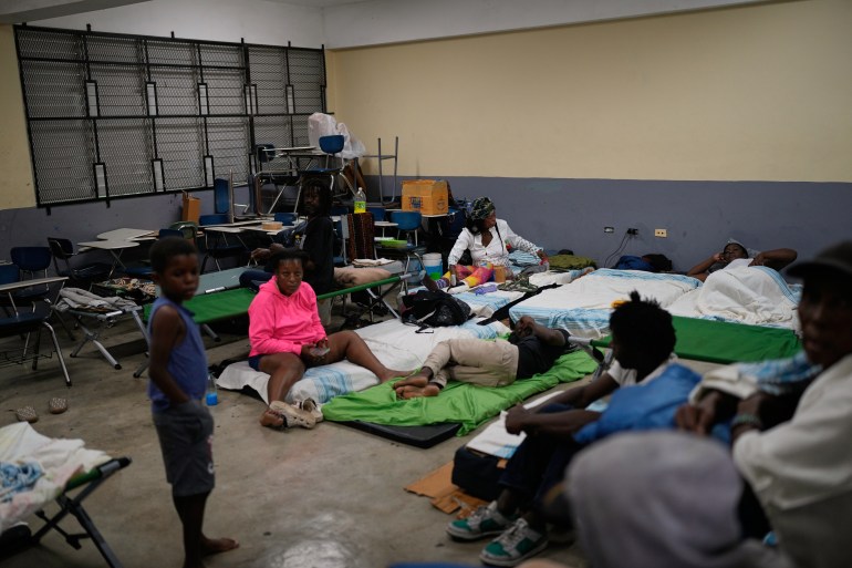 People take shelter in a school ahead of Hurricane Melissa's forecast arrival in Old Harbour, Jamaica, Monday, Oct. 27, 2025.