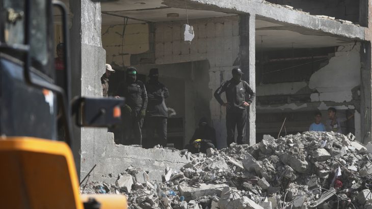 Members of the al-Qassam Brigades, the military wing of Hamas, along with Egyptian workers and machinery, search for the bodies of hostages in Nuseirat, Gaza Strip, Tuesday, Oct. 28, 2025