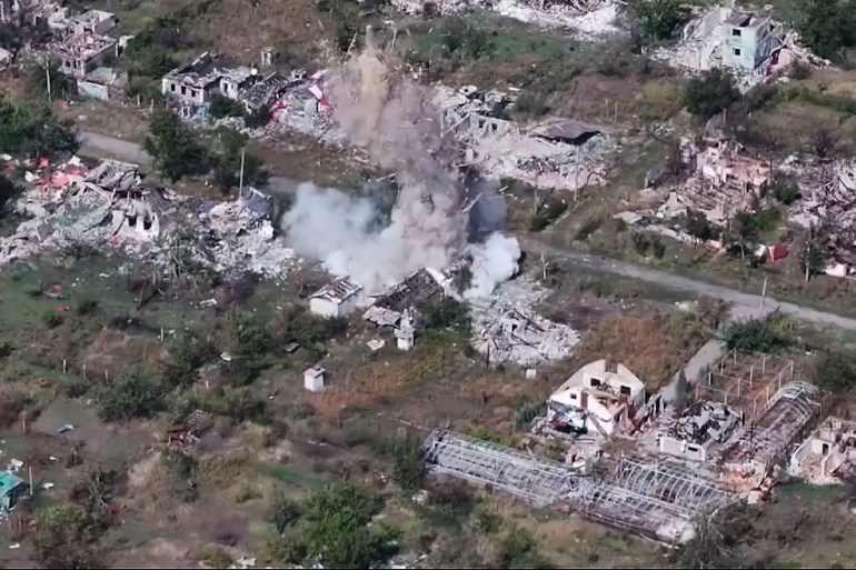 In this image made from video provided by Russian Defense Ministry Press Service on Tuesday, Oct. 28, 2025, a shell explodes in a village after a Russian gun is fired, on an undisclosed location in Ukraine. (Russian Defense Ministry Press Service via AP)