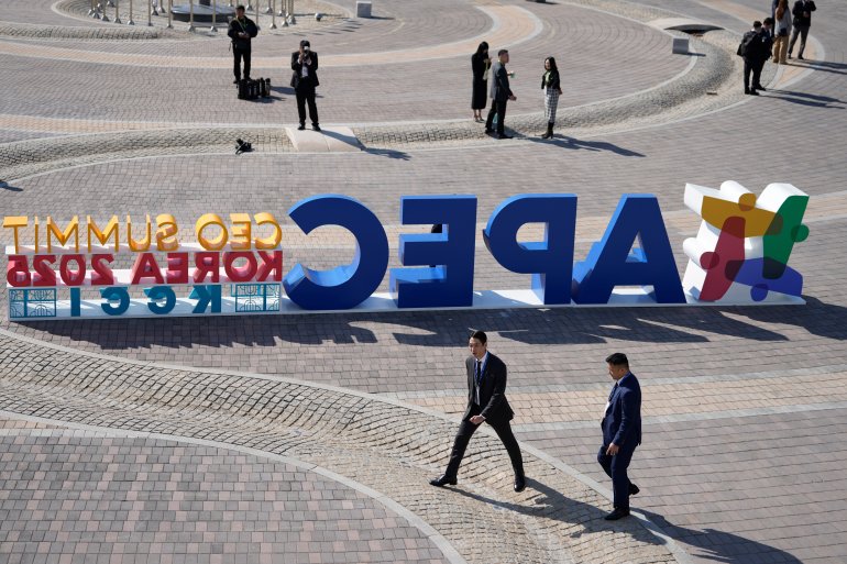 Attendees walk near a logo for the Asia-Pacific Economic Cooperation (APEC) CEO summit in Gyeongju, South Korea, Wednesday, Oct. 29, 2025. (AP Photo/Ng Han Guan)