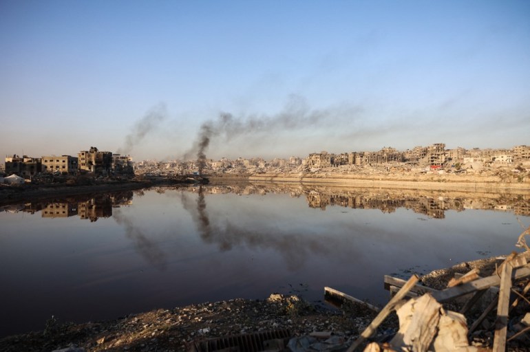 Heavily damaged buildings are reflected in a water basin in the Sheikh Radwan neighborhood of Gaza City on October 22, 2025. [File: Omar Al-Qattaa/AFP]
