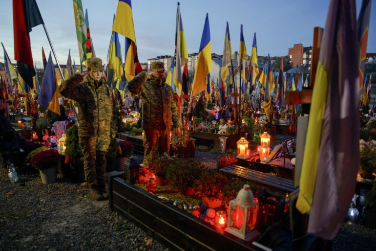 epa12495757 Soldiers salute as they visit the graves of Ukrainian soldiers killed in the armed conflict with Russia at the Lychakiv Cemetery in Lviv, Western Ukraine, 31 October 2025, as Ukrainian Greek Catholics mark All Saints' Day and Day of the Dead amid the ongoing Russian invasion. EPA/MYKOLA TYS