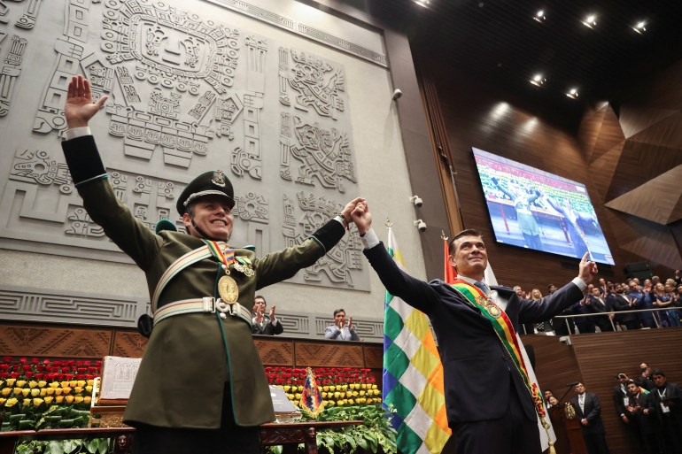 Bolivian President-elect Rodrigo Paz reacts and Vice President-elect Edmand Lara raise their arms Paz's swearing-in ceremony at the Plurinational Legislative Assembly in La Paz, Bolivia, November 8, 2025.