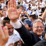 a man in a suit smiles in a crowd