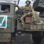 In this image, made from video and provided by Russian Defense Ministry Press Service on Thursday, Nov. 6, 2025, Russian soldiers ride a Tornado-G self-propelled multiple rocket launcher to fire towards Ukrainian positions on an undisclosed location in Ukraine. (Russian Defense Ministry Press Service via AP)