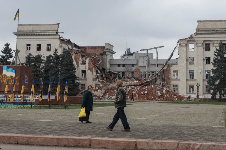 People walk near a building hit during a Russian military strike, amid Russia's attack on Ukraine, in the frontline city of Kherson, Ukraine November 11, 2025. REUTERS/Nina Liashonok